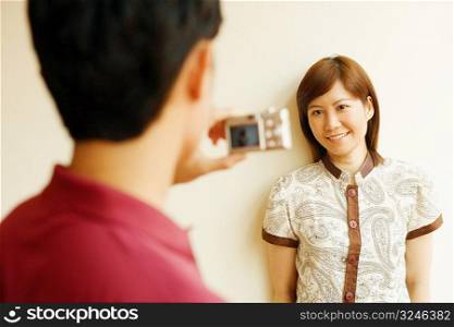 Young man taking a picture of a young woman