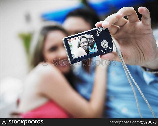 Young man taking a picture of himself with a young woman