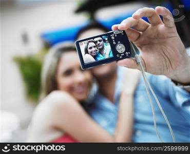 Young man taking a picture of himself with a young woman