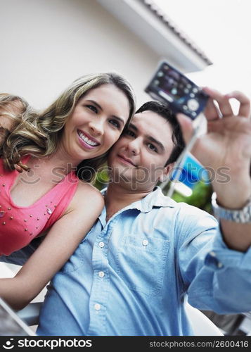 Young man taking a picture of himself with a young woman