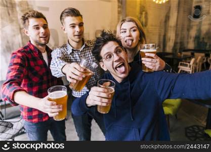 young man taking selfie mobile phone with his friends holding glasses beer