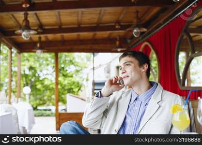 Young man talking on mobile phone in a restaurant