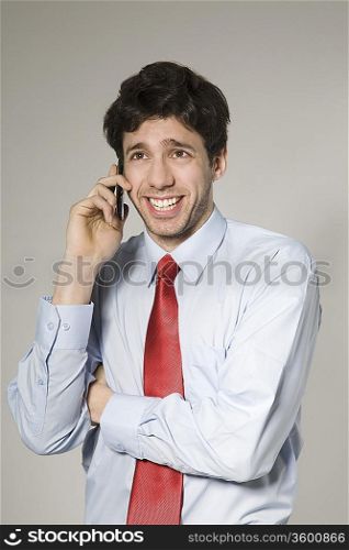 Young man talking on mobile phone, studio shot