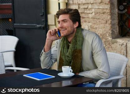 Young man talking smartphone phone in an cafe outdoor sitting having some coffe