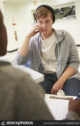 Young Man Talking To Counsellor Who Takes Notes