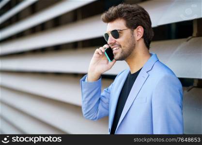 Young man talking to his smartphone with a happy expression. Man talking to his smartphone with a happy expression