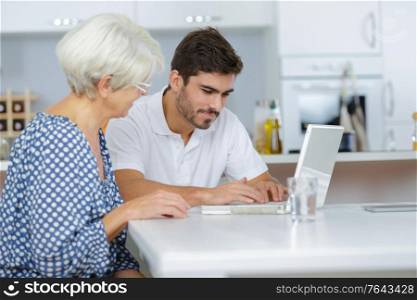 young man teaches her grandmother to work on the computer