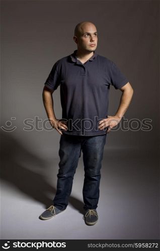 young man thinking full length on a dark background