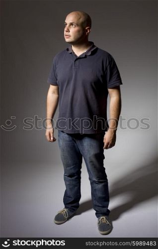 young man thinking full length on a dark background
