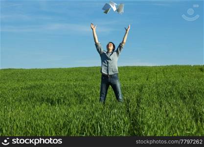 young man throwing a paper in the green field