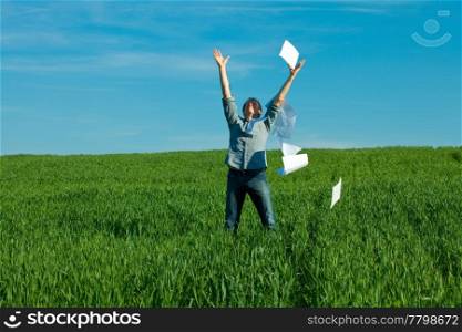 young man throwing a paper in the green field