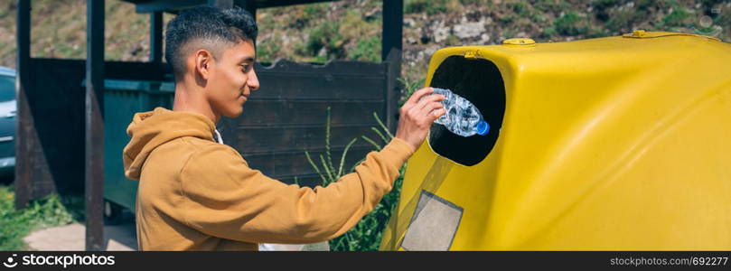 Young man throwing plastic garbage to container. Man throwing garbage to container