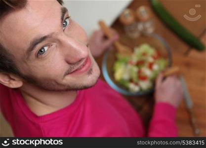 Young man tossing a salad