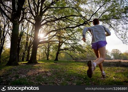 Young man trail running in a forest.
