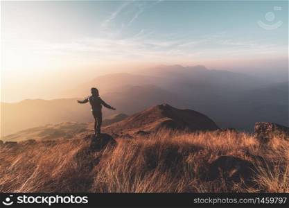 Young man traveler looking beautiful landscape at sunset on mountain, Adventure travel lifestyle concept