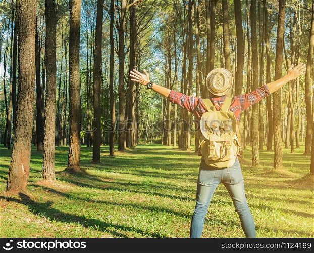 Young Man Traveler with backpack open arm relaxing outdoor on background fir park Summer vacations and Lifestyle hiking concept.