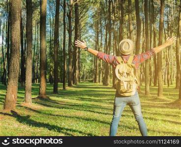 Young Man Traveler with backpack open arm relaxing outdoor on background fir park Summer vacations and Lifestyle hiking concept.