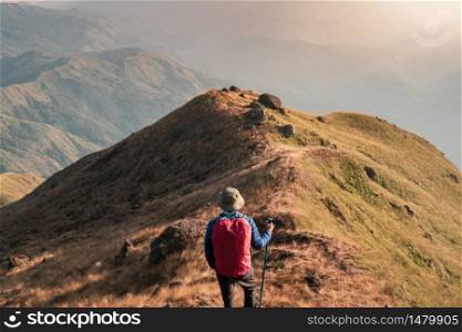 Young man traveler with backpack trekking on mountain, Adventure travel lifestyle concept