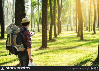 Young Man Traveler with backpack, Viewing map in digital mobile phone relaxing outdoor on background Summer vacations and Lifestyle hiking concept.