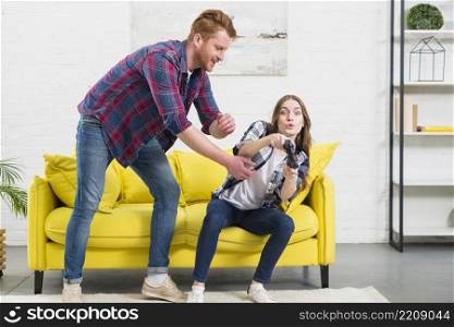 young man trying take joystick from his girlfriend s hand home