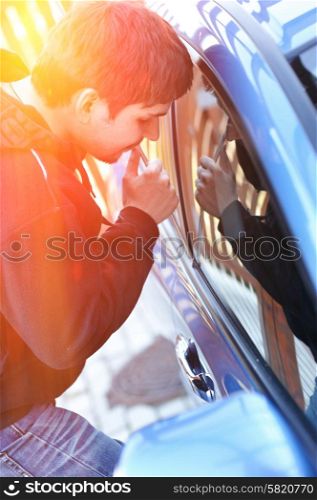 Young man trying to steal a car