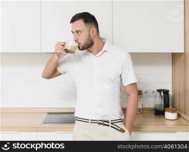 young man tshirt sipping coffee kitchen