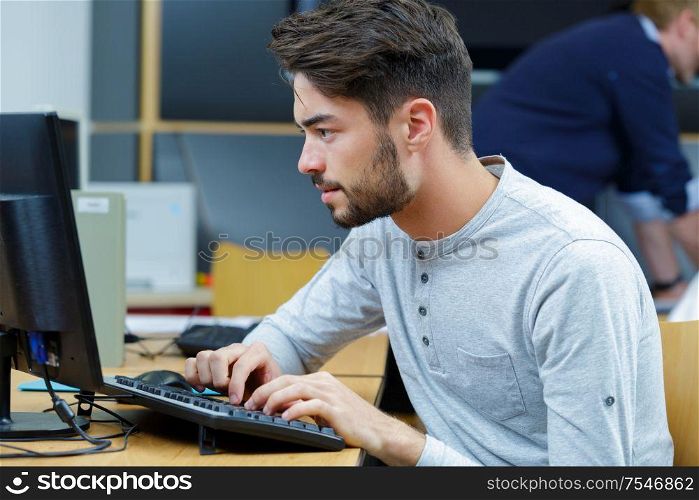 young man typing on a laptop keyboard