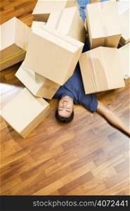 Young man under a pile of boxes