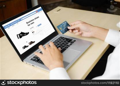 Young man use credit card for shopping payment online on laptop computer application or website. E-commerce and online shopping concept.. Young man use credit card for online shopping