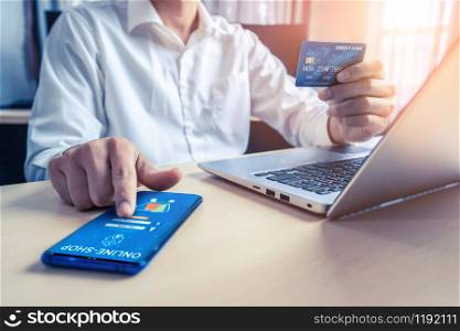 Young man use credit card for shopping payment online on laptop computer application or website. E-commerce and online shopping concept.. Young man use credit card for online shopping