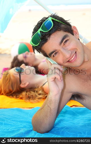 Young man using a cellphone on the beach