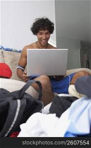 Young man using a laptop and smiling