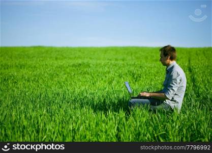 Young man using a laptop outdoors