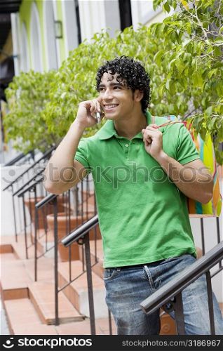 Young man using a mobile phone and smiling