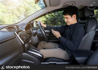 young man using a smartphone while driving a car
