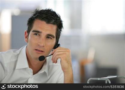 Young man using a telephone headset