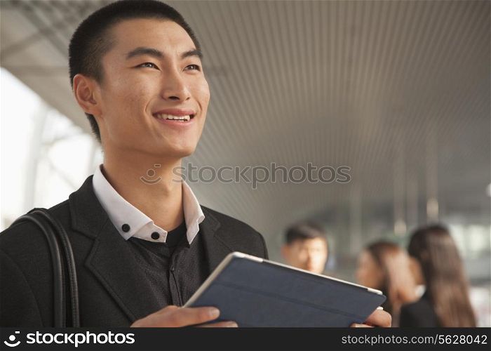 Young Man Using Digital Tablet on Train Platform