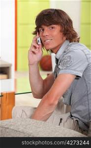 Young man using his cellphone indoors