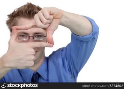 Young man using his fingers to frame his glasses