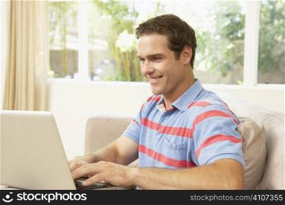 Young Man Using Laptop At Home