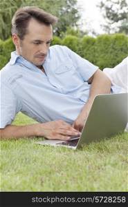 Young man using laptop in park