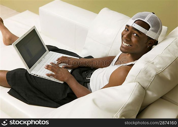 Young Man Using Laptop on Couch