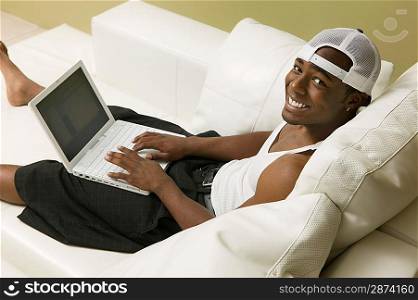 Young Man Using Laptop on Couch