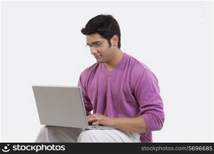 Young man using laptop over white background
