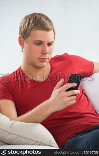 Young man using mobile phone to send short message and watch news in social media