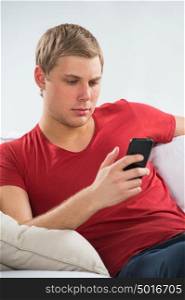Young man using mobile phone to send short message and watch news in social media
