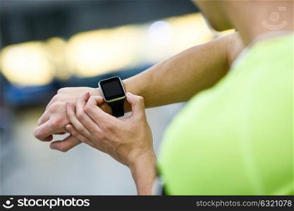 Young man using smartwatch at the gym. Caucasian male working out.