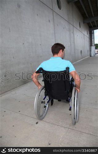 Young man using wheelchair in town
