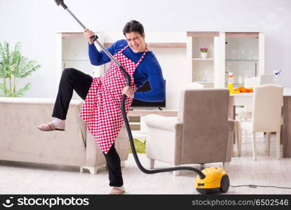 Young man vacuum cleaning his apartment