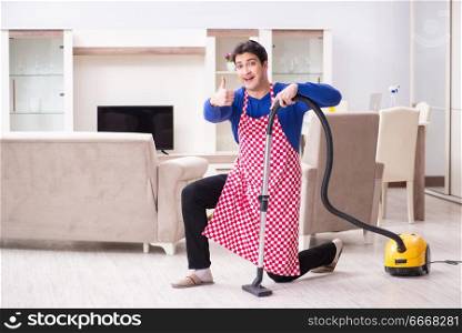 Young man vacuum cleaning his apartment